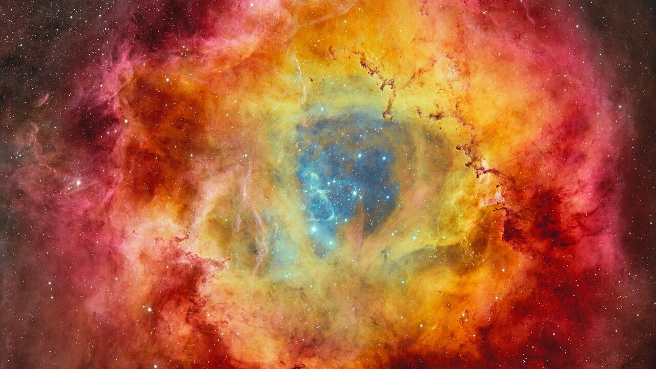 A vast, glowing nebula of pink and blue cosmic gas